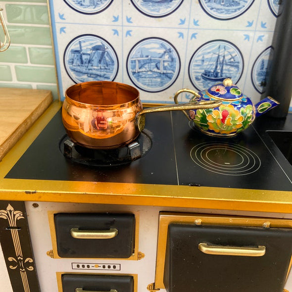 Mini copper saucepan over stove   
